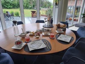 uma mesa de madeira com comida em cima em Sherlock's Home - Guest House em Namur