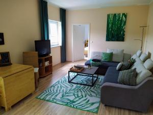 ein Wohnzimmer mit einem Sofa und einem Tisch in der Unterkunft Entspannen im Grünen, Ferienwohnung mit eigenem Garten in Keilberg