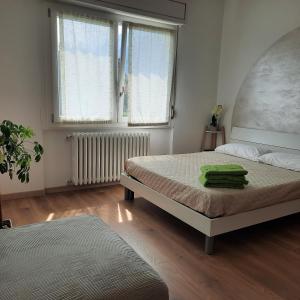 1 dormitorio con 2 camas y 2 ventanas en Sprio House, en Omegna
