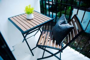 una mesa y una silla con una planta en el balcón en 503 One Pontefino Towers en Batangas