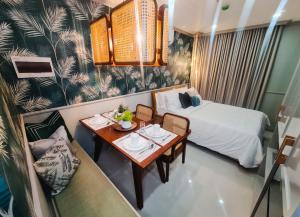 a hotel room with a bed and a table with a table at 503 One Pontefino Towers in Batangas City