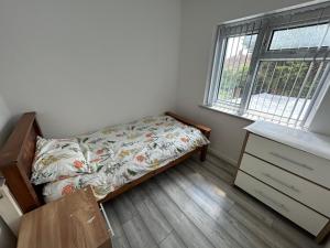 a bedroom with a bed and a desk and a window at Lovely 3 Bedroom Entire Home With Street Parking - Close to NEC, BHX Airport - Sleeps 6 Guests IDEAL FOR CONTRACTORS & FAMILIES in Birmingham