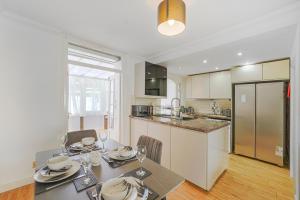a kitchen and dining room with a table and chairs at Special Offers, Sleeps 5, Hanwell, London W7, Free Parking in Greenford