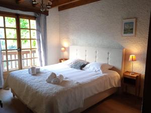 a bedroom with a large white bed with towels on it at Chalet Horizon Blanc in Megève