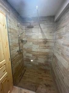 a bathroom with a shower with a stone wall at Rustic Lodge Plitvice in Jezerce
