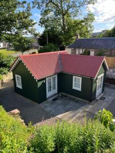 una pequeña casa verde con techo rojo en Wee House in beautiful surroundings Maybole, en Maybole