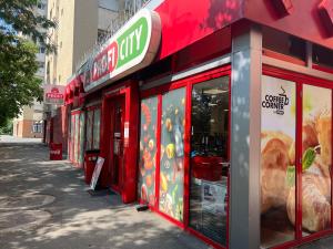 una tienda roja con carteles en una calle en Kalim’s apartment, en Arad