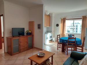 a living room with a couch and a table with a television at Alltravel Gaivota Mar in Portimão