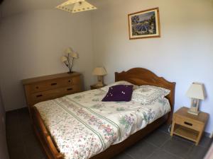 a bedroom with a bed and a dresser and two lamps at Gite Du Lavoir in Saint-Geniès-de-Comolas