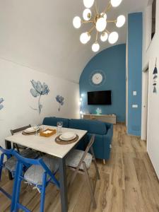 a dining room with a table and a blue couch at Dimora Nonno Ciccio in Polignano a Mare