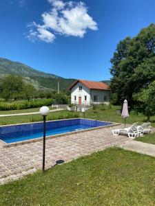 uma casa com piscina em frente a uma casa em Frutak Villa Resort em Bogićevići