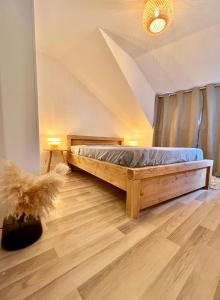 1 dormitorio con cama de madera en el ático en Un peu plus prés des étoiles, en Annecy