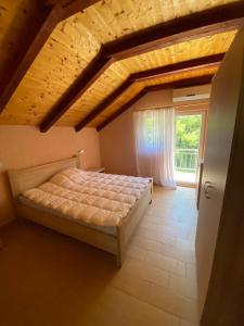 um quarto com uma cama em frente a uma janela em Frutak Villa Resort em Bogićevići