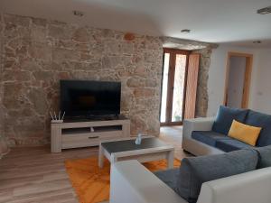 a living room with a couch and a tv at Taliscas Stone Charm in Coimbra