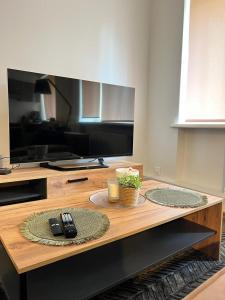 a living room with a table with a television at EVIS LTD apartments 3 in Rēzekne