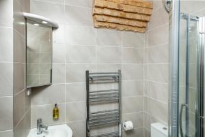a bathroom with a shower and a sink and a mirror at The Old Farmhouse at Roughs Farm Retreats in Huntingdon +34 photos