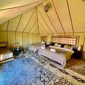 a room with two beds in a tent at Blue Sky Luxury Camp in Merzouga