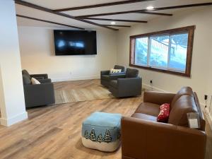 a living room with two couches and a flat screen tv at The Lodge at Silver Ridge Ranch in Cabin Creek