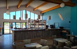 un ristorante con bar, tavoli e sedie di Mobil-home Les Dunes de Contis a Saint-Julien-en-Born