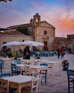 a group of tables and chairs in front of a building at Casa Marsilla in Marzamemi