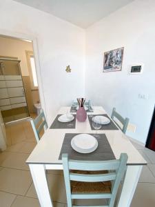 una sala da pranzo con tavolo e sedie bianchi di Casa Marsilla a Marzamemi