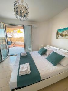 a bedroom with a large bed with green pillows at Casa Marsilla in Marzamemi