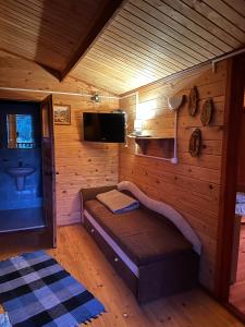 a small room with a bed in a wooden cabin at Eko-Wakacje in Polańczyk