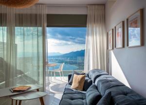 a living room with a couch and a large window at Lithos Retreat 2 in Kalamata