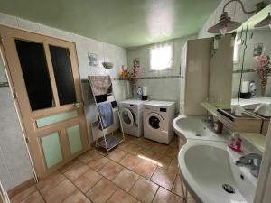 łazienka z umywalką i pralką w obiekcie Gîte au coeur de la Touraine w mieście La Chapelle-sur-Loire
