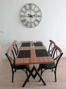 una mesa con dos sillas y un reloj en la pared en Best Apartments-Aqua-Belgrade Waterfront, en Belgrado