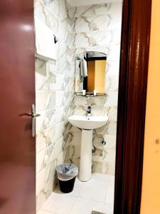 uma casa de banho com um lavatório e um espelho em Relax Inn Furnished Apartments Hawally em Kuwait