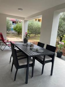 a black dining table and chairs on a patio at Apartmani Stellar in Malinska