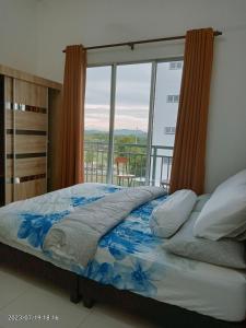 een slaapkamer met een bed en een groot raam bij Homestay Triple Q Manjung in Seri Manjung