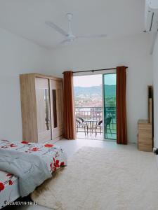 a bedroom with a bed and a balcony with a view at Homestay Triple Q Manjung in Seri Manjung