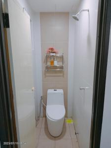 a white bathroom with a toilet in a stall at Homestay Triple Q Manjung in Seri Manjung