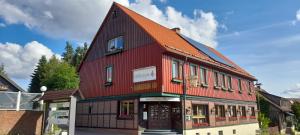 ein rotes Gebäude mit rotem Dach in der Unterkunft Hotel Silbertanne in Hohegeiß