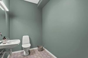 La salle de bains est pourvue de toilettes blanches et d'un lavabo. dans l'établissement Svanøy Gjestehus, à Florø