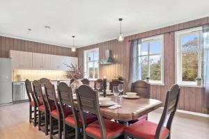 Il comprend une cuisine et une salle à manger avec une table et des chaises en bois. dans l'établissement Svanøy Gjestehus, à Florø