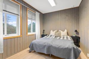 - une chambre avec un lit et 2 fenêtres dans l'établissement Svanøy Gjestehus, à Florø