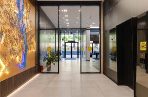 una hall con ufficio e corridoio con porte in vetro di Be The One Hotel a Kiev