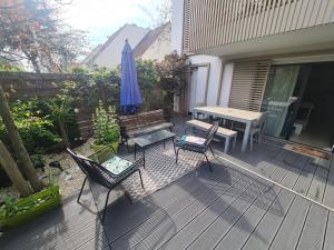 a patio with a table and a bench and an umbrella at Superbe Appartement 3 pièces près de la Défense in Nanterre
