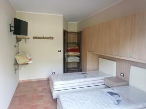 Habitación con 2 camas y espejo. en Le Stanze di Bacco en Cagnano Amiterno
