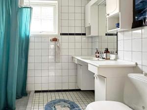 Baño blanco con lavabo y aseo en Holiday home Skjærhalden, en Skjærhollen
