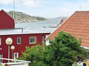 un edificio rojo con un río al fondo en Holiday home Skjærhalden, en Skjærhollen
