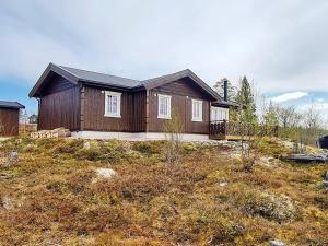 a wooden house on a hill with a yard at Holiday home Engerdal 