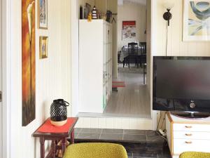 a living room with a flat screen tv and a hallway at Holiday home Klokkarstua in Svelvik