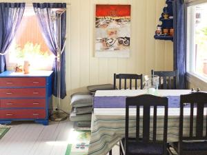 a bedroom with a bed and a table and chairs at Holiday home Klokkarstua in Svelvik