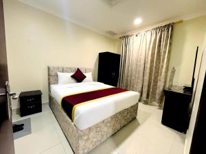 Relax Inn Furnished Apartments Hawally في الكويت: غرفة نوم بسرير كبير في غرفة