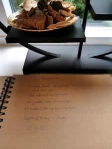 ręczna notatka z talerzem jedzenia na stole w obiekcie Chalet Het Bosnestje Durbuy w mieście Durbuy