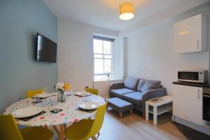 a living room with a table and a couch at Cosy & Central Broughton 2BR Apt near City Centre in Edinburgh